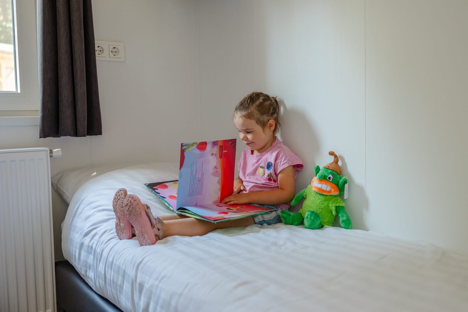 Kind zit op het bed met Bosmannetje
