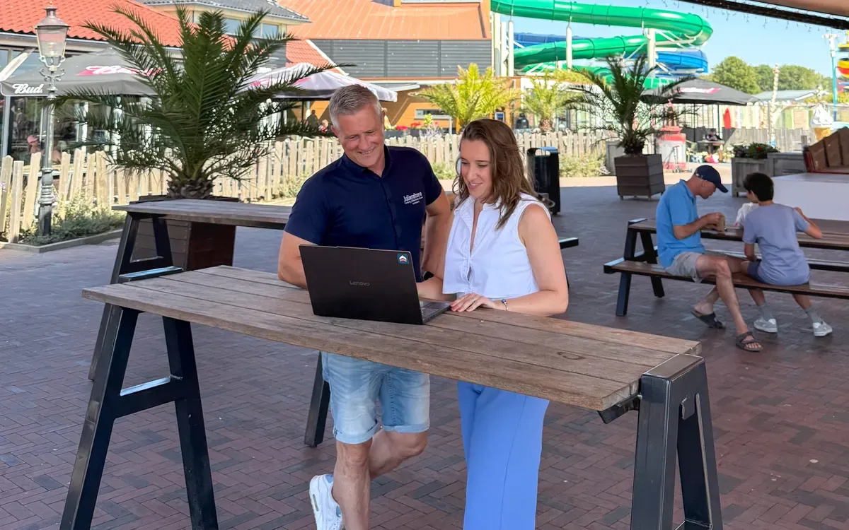 Marketeer van UPPER bespreekt de cijfers met de campingeigenaar aan een statafel op het park